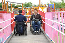 写真：幅の広いスロープですれ違う車いすの検証者二人