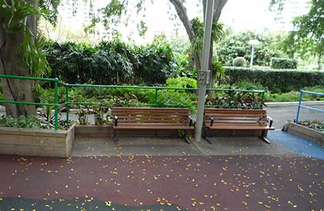 写真：2つのベンチが置かれたコーナー。ベンチと隣の花壇の間には1メートルほどの空間