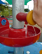 写真：水遊びテーブルの蛇口ボタン。押している間、水が流れ出る 