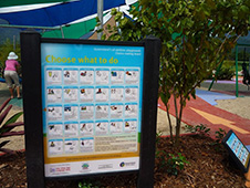 写真：遊び場の植栽部分に設置された大きな看板と小さな看板。 