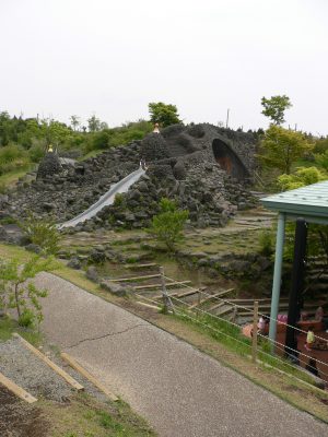 写真：溶岩谷の遊び場。黒い岩を積み上げた山の上につくられた滑り台