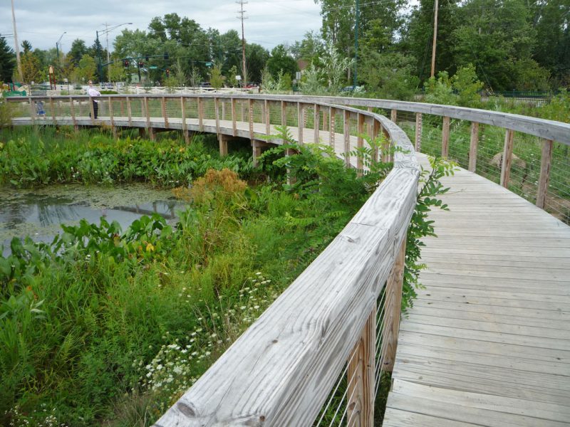 写真：池に架かる板張りの橋が大きくカーブしている