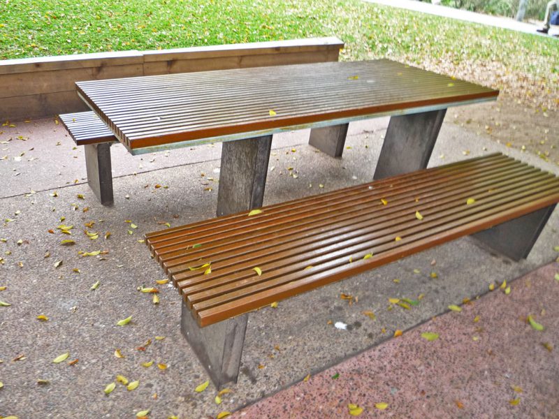 写真：長方形のテーブルの両脇にベンチ。テーブルの天板を下で支える2枚の板は本来の位置よりずれた場所にある
