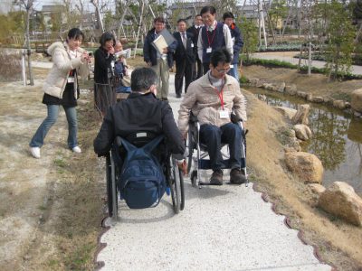 写真：車いすユーザーとともに園路を検証する様子