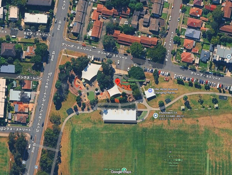 航空写真：住宅街の交差点の一角に面した遊具広場。南側には芝のフィールドが広がっている。