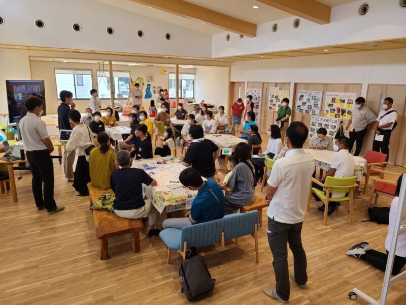 写真:50人弱の人がテーブルに分かれ、公園について意見を出し合う。