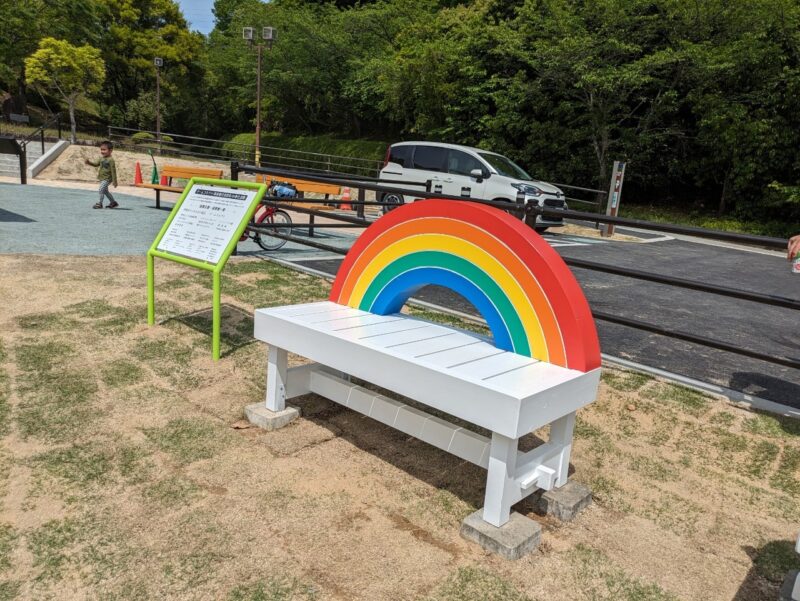 写真:寄贈された白いベンチ。背もたれはカラフルな虹の形。