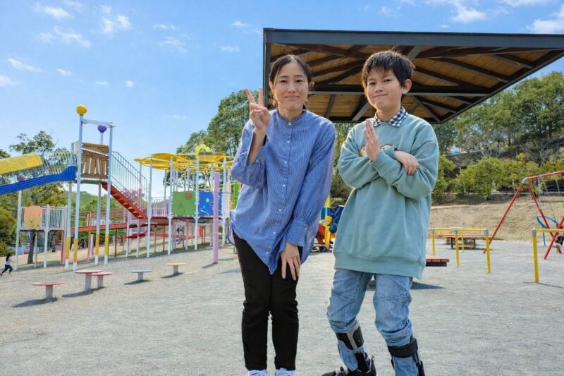 写真:遊び場で並んで笑顔を見せる松元さんとゆうらくん。