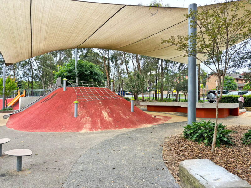 写真：土手の頂上の先端の斜面に張られた、目の大きなネット遊具。