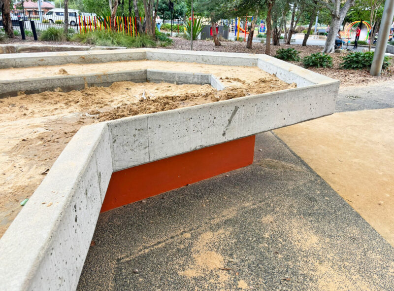 写真：テーブルのような高さのレイズド砂場。砂はかなり減っているが、手前の浅い部分に砂山をつくり遊んだ跡がある。